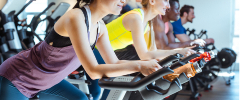 Men and women exercising on indoor spin bikes