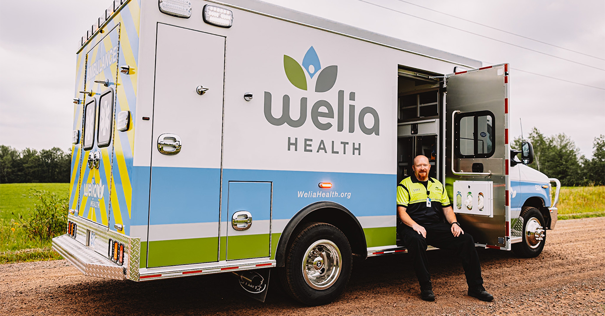 Welia Health EMT, Mike Smith sitting in the door of his 'rig' -- a Welia Health ambulance