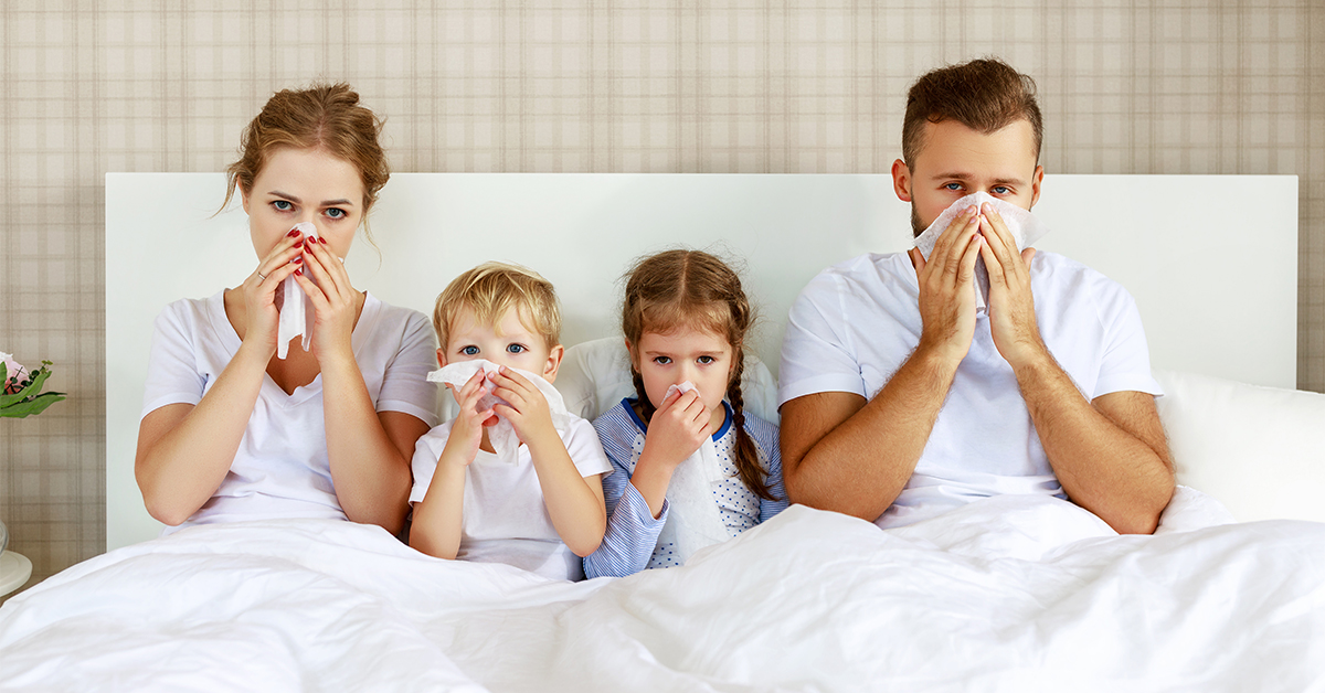 Mom, Dad and two kids in bed with the flu