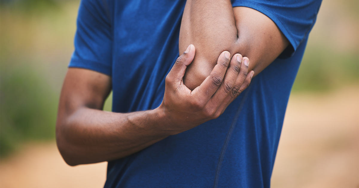 Close up of man holding his elbow in pain